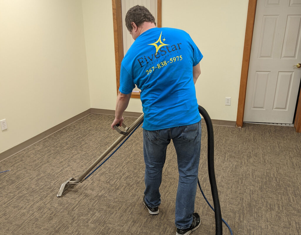 Carpet Cleaning Wyncote Five Star Carpet Service technician using a portable extractor wand for deep carpet cleaning in a sunny Bensalem, PA home